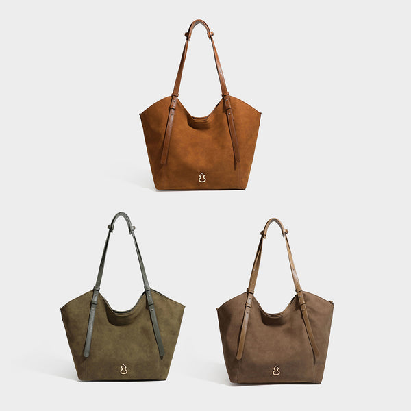 Oversized suede-finish tote shoulder bag in caramel brown with slim leather-look straps and gold-tone logo hardware, detail
