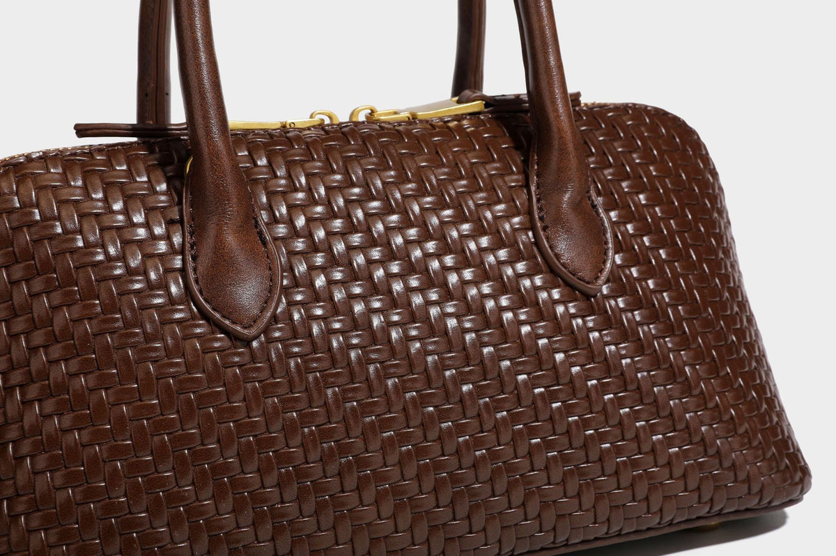 Structured woven-embossed leather-look satchel with dual rolled top handles, gold-tone turn-lock closure, and detachable