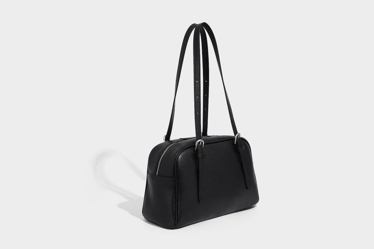 Structured dome-shaped shoulder bag with leather-look finish, top zipper closure, dual adjustable slim straps, and, detail