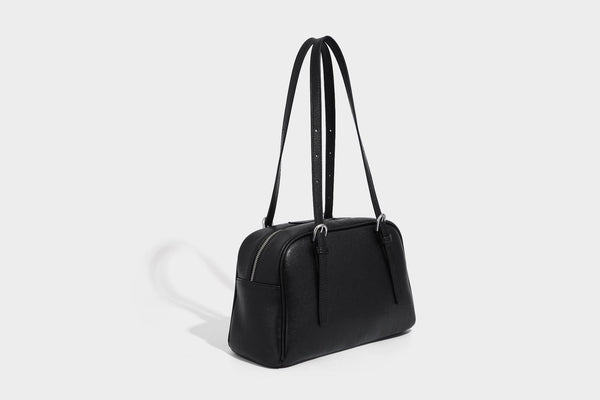 Structured dome-shaped shoulder bag with leather-look finish, top zipper closure, dual adjustable slim straps, and, detail