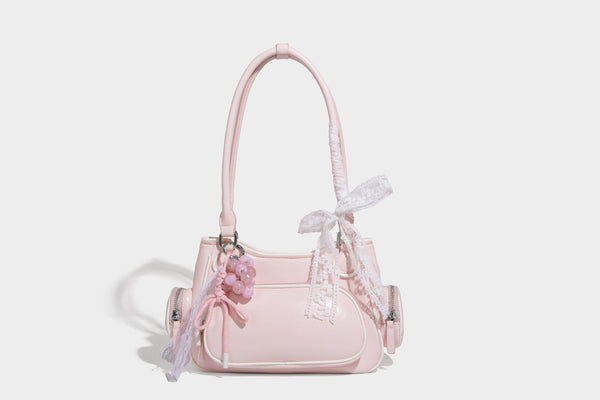 Kleine, formstabile Schultertasche mit glänzender Oberfläche, weißem Paspelbesatz, Spitzenschleife und rotem Perlenanhänger, Reißverschluss-Seitentaschen und silberfarbenem