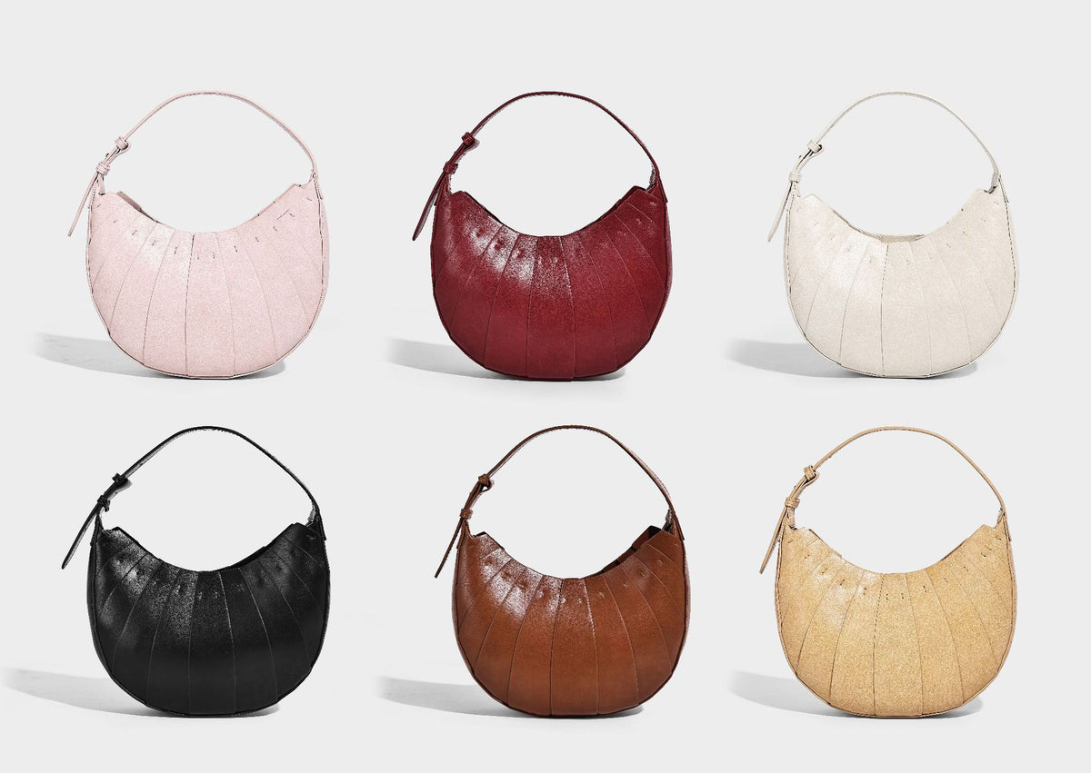 Crescent half-moon shoulder bag with vertical panel seaming, matte-satin leather-look finish, and adjustable gold-tone