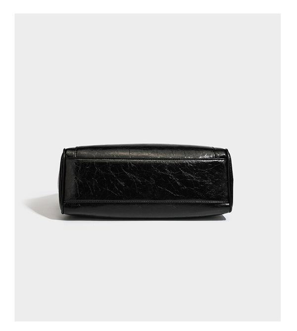 Structured glossy crinkled leather-look satchel with double top handles, front metal-plaque tab, silver-tone hardware, and