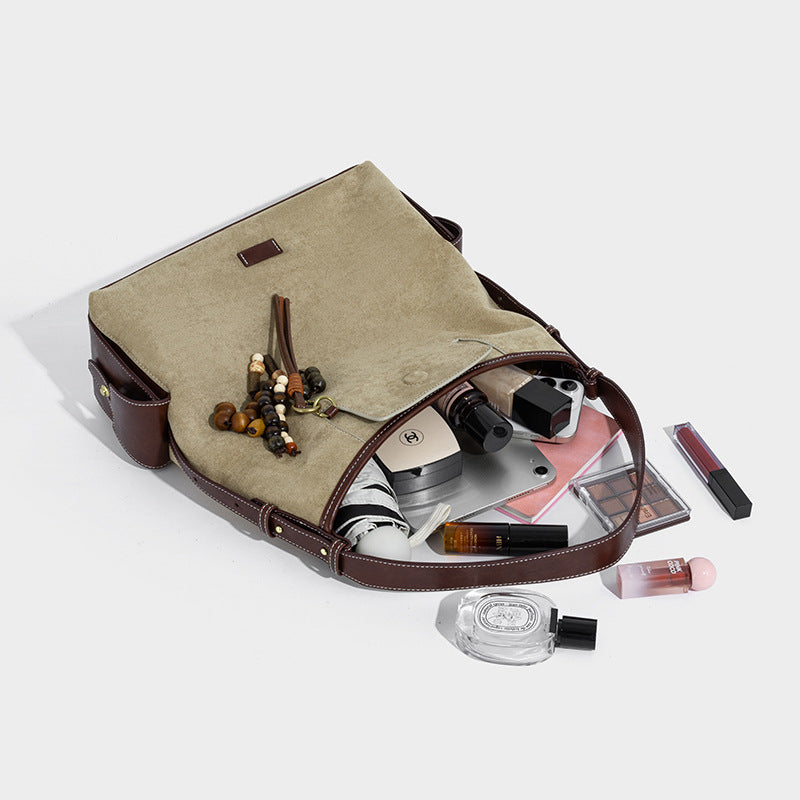 Weich fallende Hobo-Schultertasche in Khaki mit matter Velourslederoptik, Besatz in dunkelbrauner Lederoptik, Quastenanhänger mit Perlen und seitlicher Klappe, Detailansicht