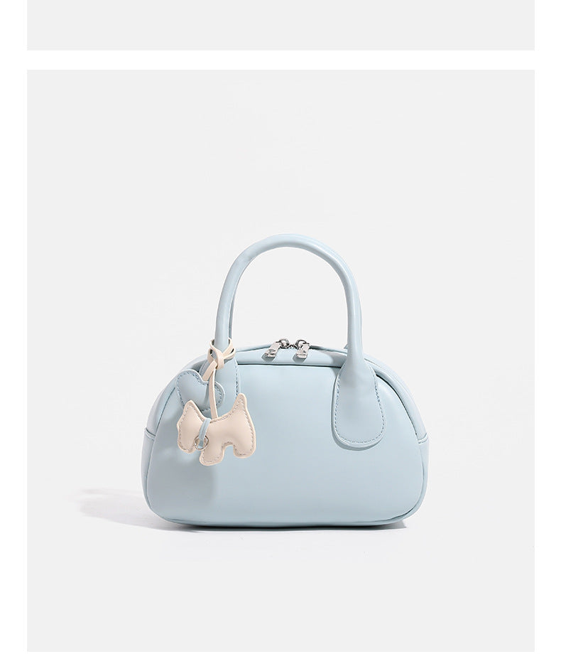 Mini-Handtasche in Kuppelform mit glatter Oberfläche in Lederoptik, zwei Henkeln, Reißverschluss oben, silberfarbenen Metalldetails und herabhängendem