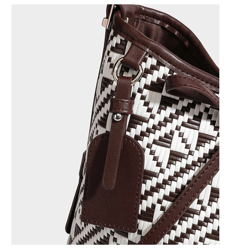 Woven geometric bucket shoulder bag in white and dark brown two-tone pattern with leather-look trim and drawstring top