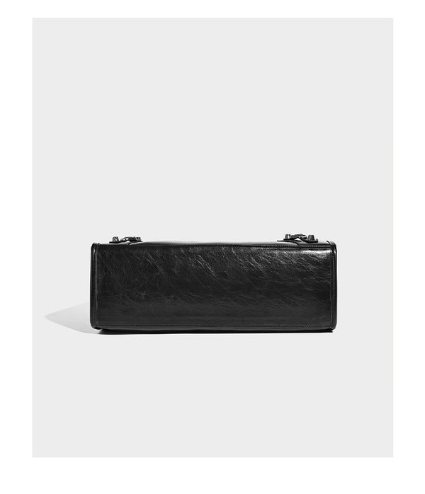 Large structured leather-look tote bag with front zip pocket, moto hardware accents, and long double shoulder straps, detail