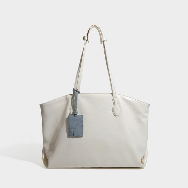 Oversized-Shopper mit lässig-weicher Form in dunkler Burgunderfarbe, glänzender geknautschter Lederoptik, zwei langen Schulterriemen und kontrastierendem