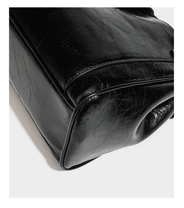 Structured glossy crinkled leather-look satchel with double top handles, front metal-plaque tab, silver-tone hardware, and