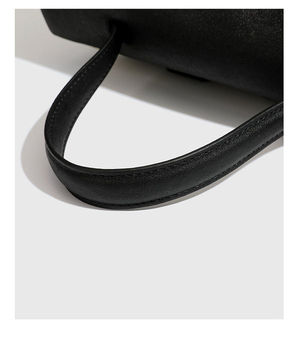 Strukturierter beigefarbener Rucksack aus gewebtem Canvas mit schwarzer Klappe in Lederoptik, Drehverschluss, Tragegriff und flachem Schulter
