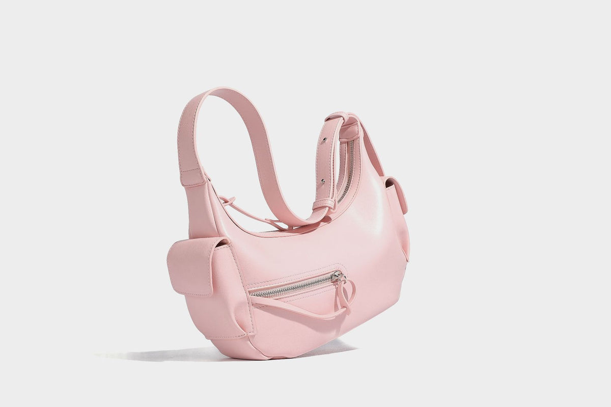 Smooth leather-look crescent shoulder bag with front zip pocket, side flap pockets, adjustable strap, and silver-tone, detail