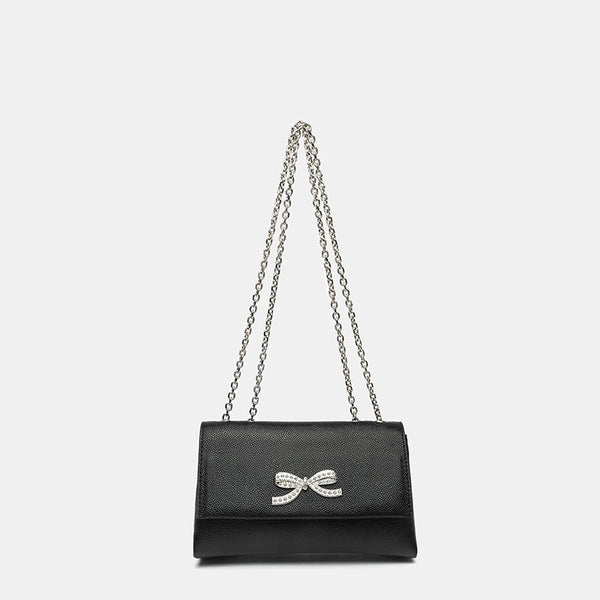 Structured rectangular flap crossbody bag with rhinestone bow and silver chain strap in pebbled finish, front view