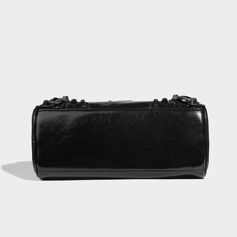 Glossy studded mini satchel bag with braided top handles, front zip pocket, heart charm, and detachable crossbody strap