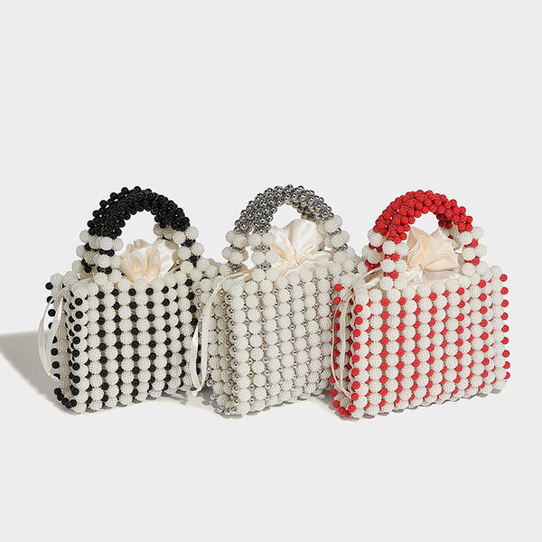 Small boxy pearl-bead mini top-handle bag with silver metallic bead accents, satin floral detail, and long beaded shoulder