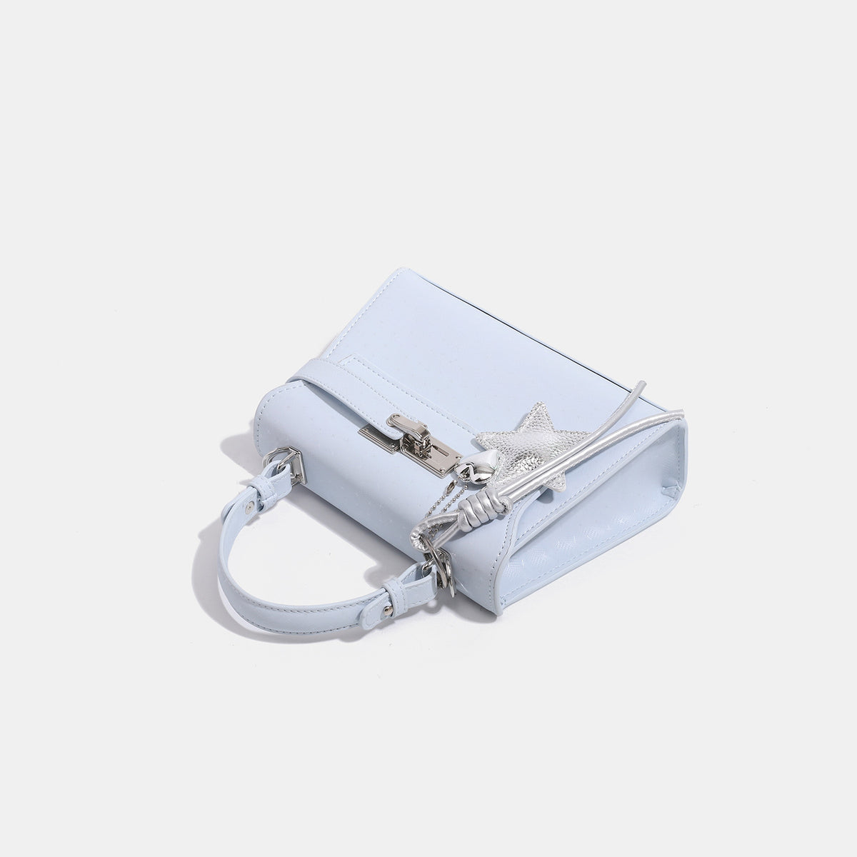 Mini-Henkeltasche in strukturierter Trapezform mit geprägter Oberfläche, silberfarbenem Drehverschluss und Sternanhänger mit Kordelquasten