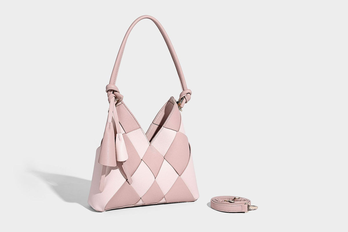 Compact bucket shoulder bag with black-and-white diamond patchwork panels, knotted top handle, gold-tone hardware, and