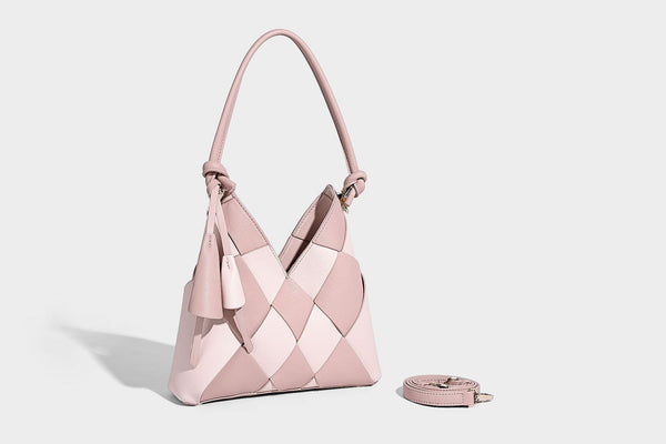 Compact bucket shoulder bag with black-and-white diamond patchwork panels, knotted top handle, gold-tone hardware, and