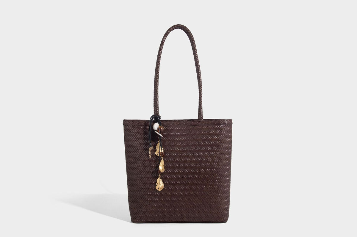 Structured woven herringbone tote bag with braided double shoulder handles in tan brown, shown with matching drawstring