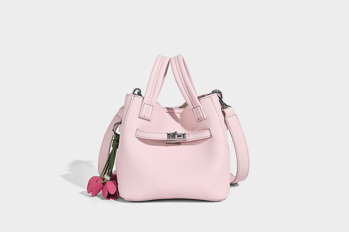 Small structured pebbled bucket tote bag with dual top handles, silver turn-lock front pocket, and detachable shoulder strap
