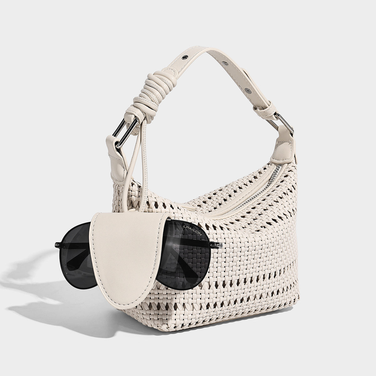Kleine Hobo-Schultertasche mit geflochtener Gitterstruktur und sichelförmiger Silhouette, Reißverschluss oben, Beschlägen in Silberoptik und verstellbarem Riemen, Detailansicht