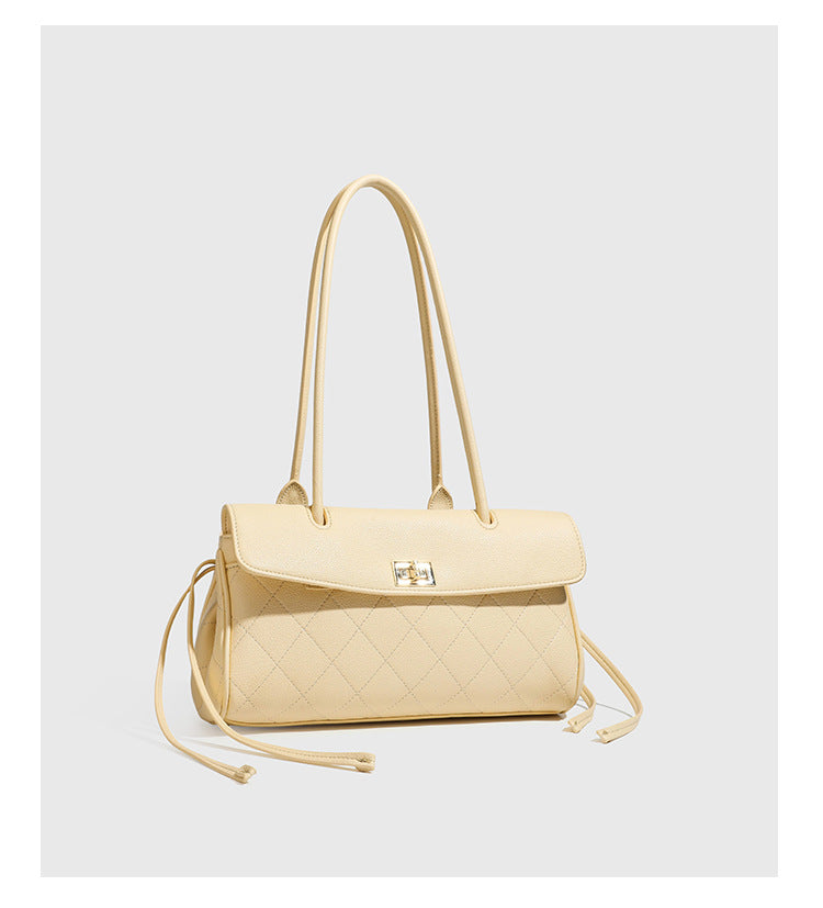 Structured black diamond-quilted shoulder bag with gold-tone turn-lock flap closure and dual round shoulder straps, detail