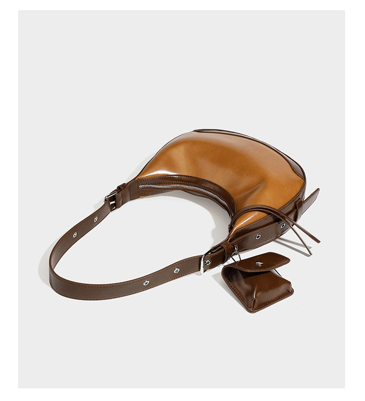 Glossy leather-look crescent hobo shoulder bag with dark contrast trim, silver-tone hardware, and attached mini flap pouch
