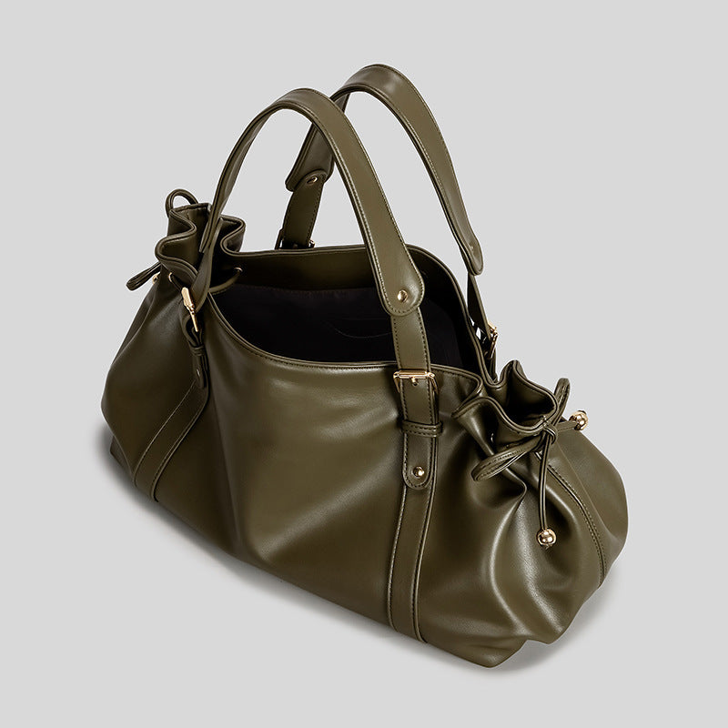 Slouchy barrel tote bag with drawstring side ties, dual top handles, and gold-tone buckle hardware, detail view 2