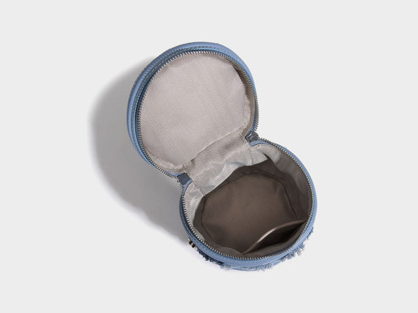 Mini cylindrical barrel bucket bag in denim patchwork with frayed edges, smooth leather-look trim, zip-around top closure