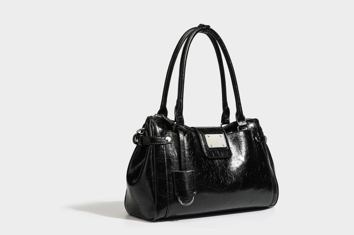 Structured glossy crinkled leather-look satchel with double top handles, front metal-plaque tab, silver-tone hardware, and