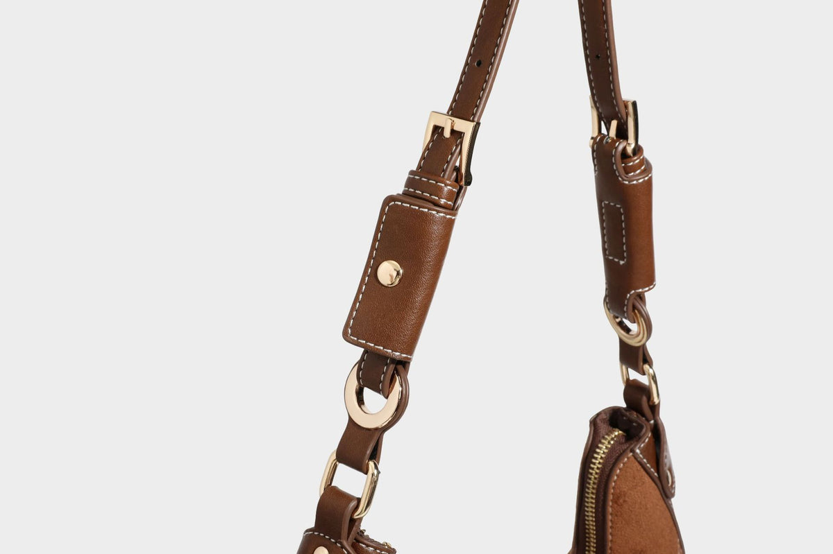 Halbmondförmige Schultertasche in camelbrauner Wildlederoptik mit weißen Kontrastnähten, goldfarbenen Beschlägen und