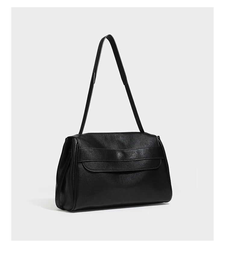 Strukturierte rechteckige dunkelbraune Schultertasche in Lederoptik mit Klappe, mehrlagigem Detail auf der Vorderseite und langem verstellbarem Riemen, Detailansicht