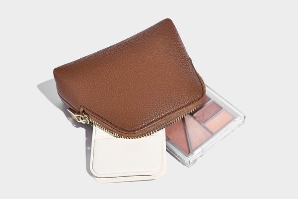 Structured pebbled-texture bucket bag with arched top handles, gold-tone turn-lock closure, and detachable shoulder strap