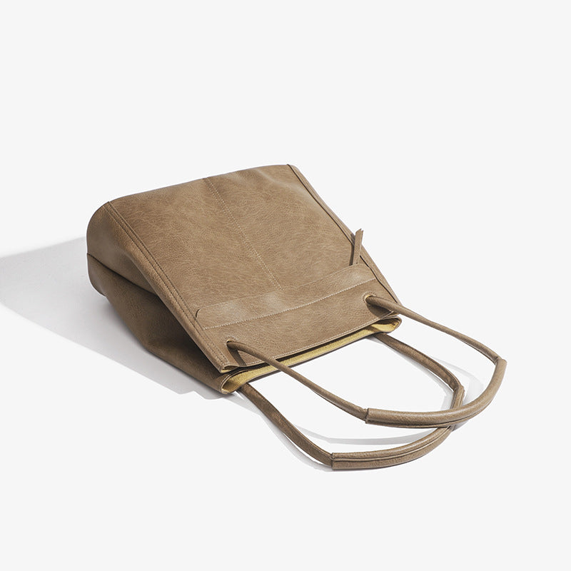 Retro structured matte leather-look tote bag in camel with front flap pocket, tassel pull, and double top handles, detail