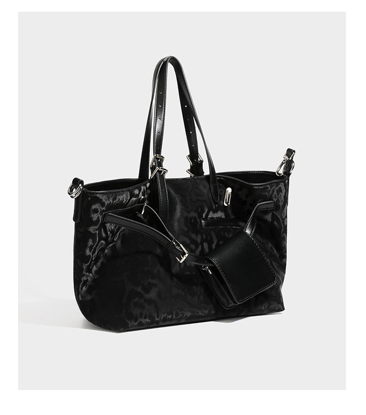 Glossy leopard-print tote bag with leather-look dark trim, dual top handles, detachable shoulder strap, and attached front