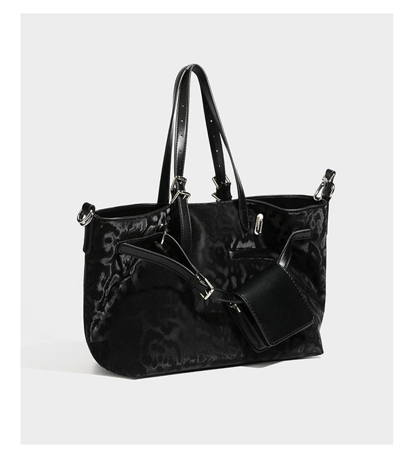 Glossy leopard-print tote bag with leather-look dark trim, dual top handles, detachable shoulder strap, and attached front