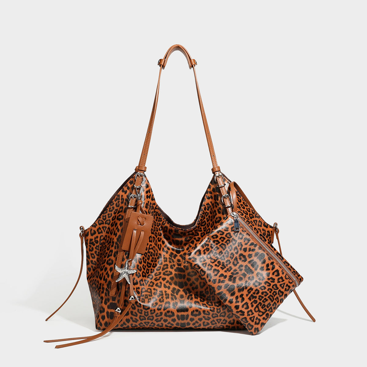 Large leopard print shoulder tote bag with glossy finish, long double straps, front zip pocket, silver-tone hardware, and
