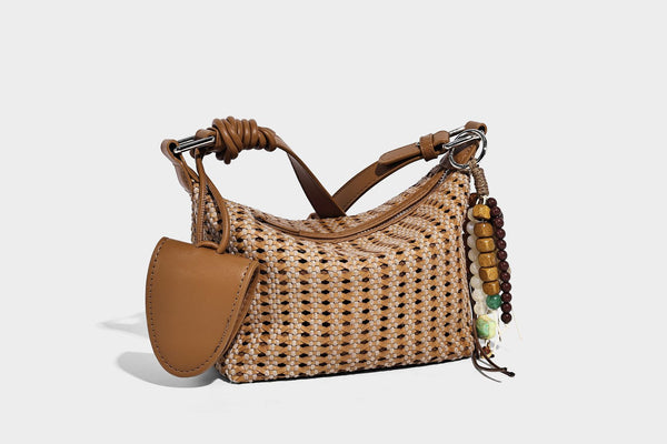 Woven crescent shoulder bag with leather-look knotted handle, zip top, attached mini pouch, and silver-tone hardware, detail