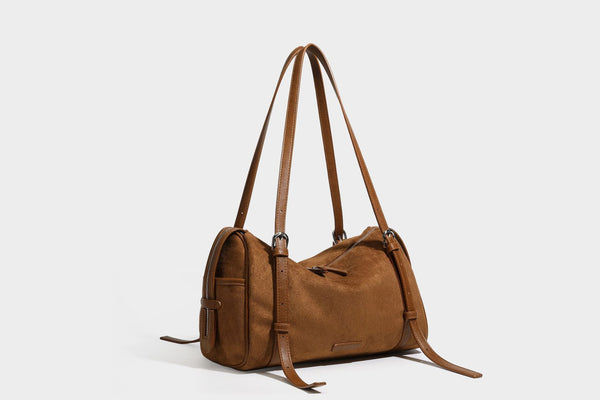 Large brown suede-finish barrel shoulder bag with dark leather-look trim, silver-tone zippers, dual top handles, and long