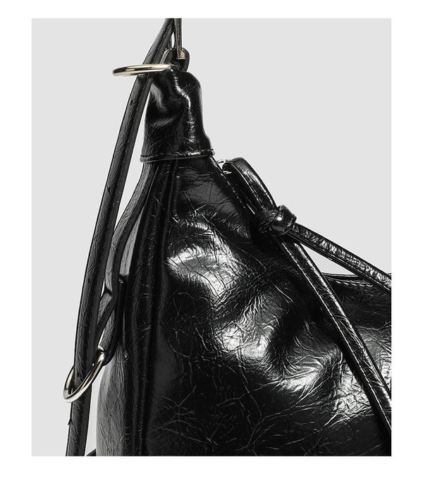 Slouchy hobo shoulder bag in glossy crinkled leather-look finish with silver-tone buckle hardware and slim adjustable strap