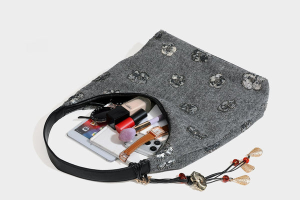 Lässig fallende, trapezförmige Schulter-Tote in Anthrazitgrau mit floralen Paillettenmotiven in Silber, Riemen in Lederoptik und herabhängendem Perlenbesatz