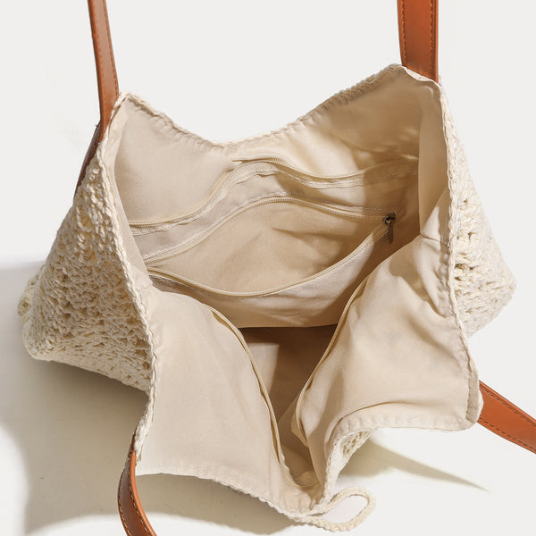 Cream openwork crochet tote bag with tan leather-look double shoulder straps and tassel drawstring tie, detail view 4