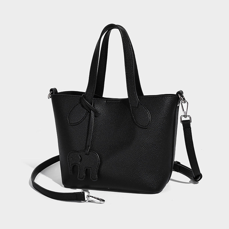 Compact pebbled bucket tote bag with elephant charm, twin top handles, and detachable crossbody strap, detail view 6
