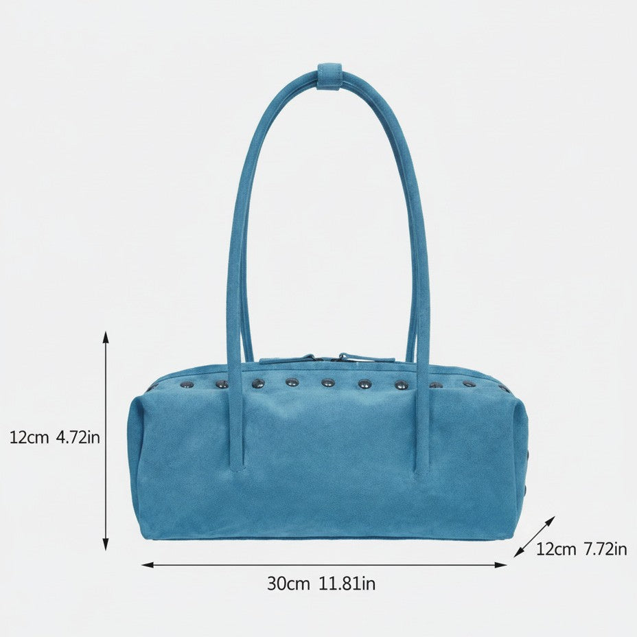 Rechteckige, tonnenförmige Schultertasche mit kuppelförmigen Nieten in Gunmetal-Optik entlang der oberen Naht, zwei flachen Riemen mit Knotendetail und mattem Finish, Detailansicht