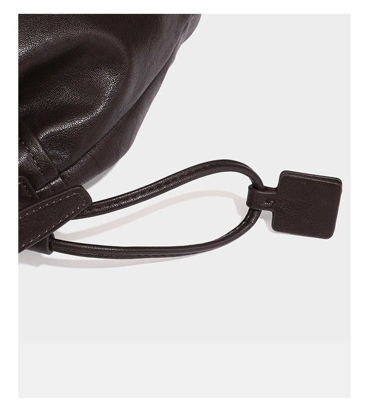 Kleine dunkelbraune Beuteltasche mit Kordelzug, langem verstellbarem Crossbody-Riemen und silberfarbenen Beschlägen, Detailansicht 21