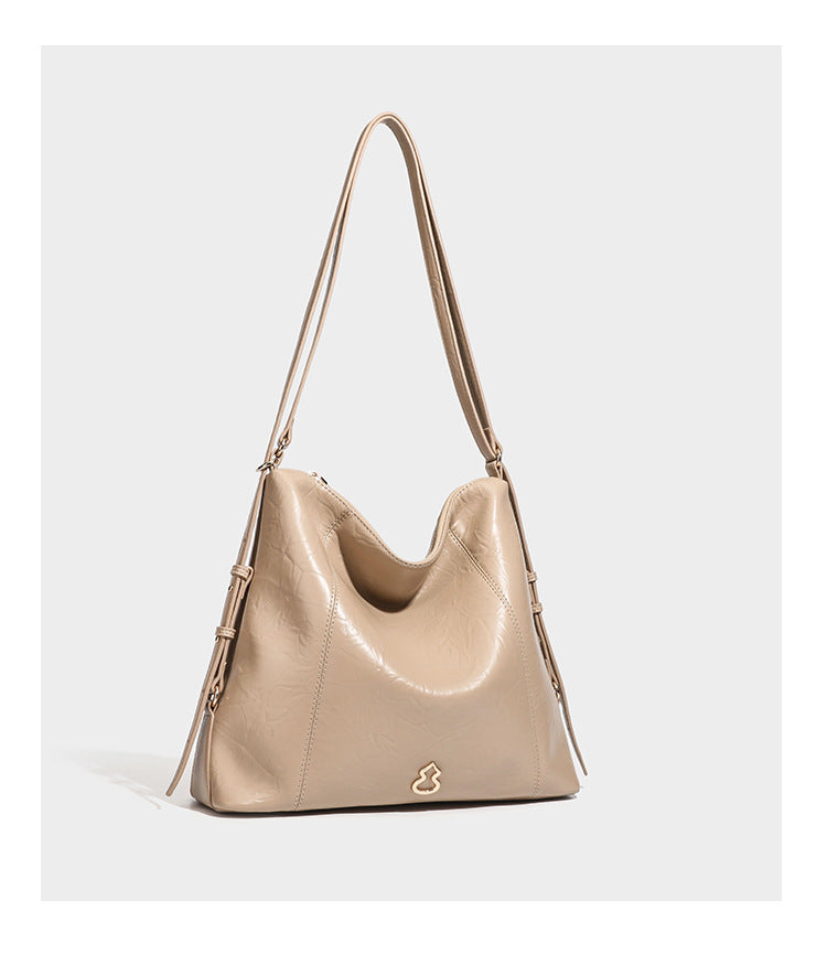 Große, lässig fallende Hobo-Schultertasche in glänzender, geknautschter Lederoptik mit goldfarbenen Beschlägen und langem, verstellbarem Riemen