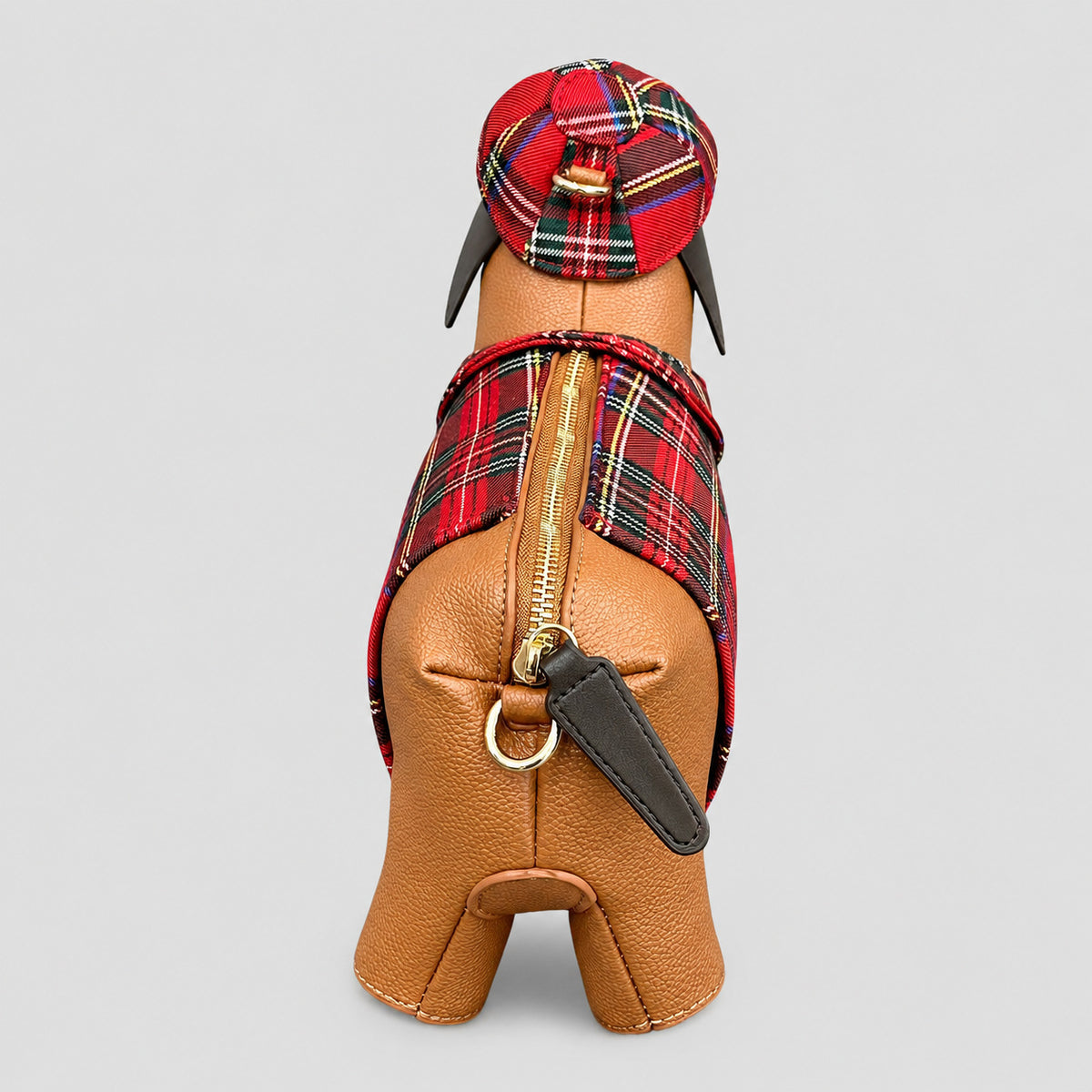 Umhängetasche in Dackelform mit roten Tartan-Einsätzen, beigefarbener Oberfläche in genarbter Optik, passender Tartan-Schiebermütze und goldfarbenem