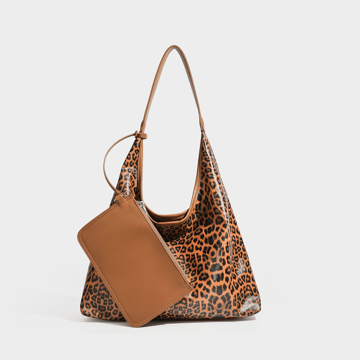 Glossy leopard-print slouchy shoulder bag with long strap and detachable tan zip pouch, detail view 4