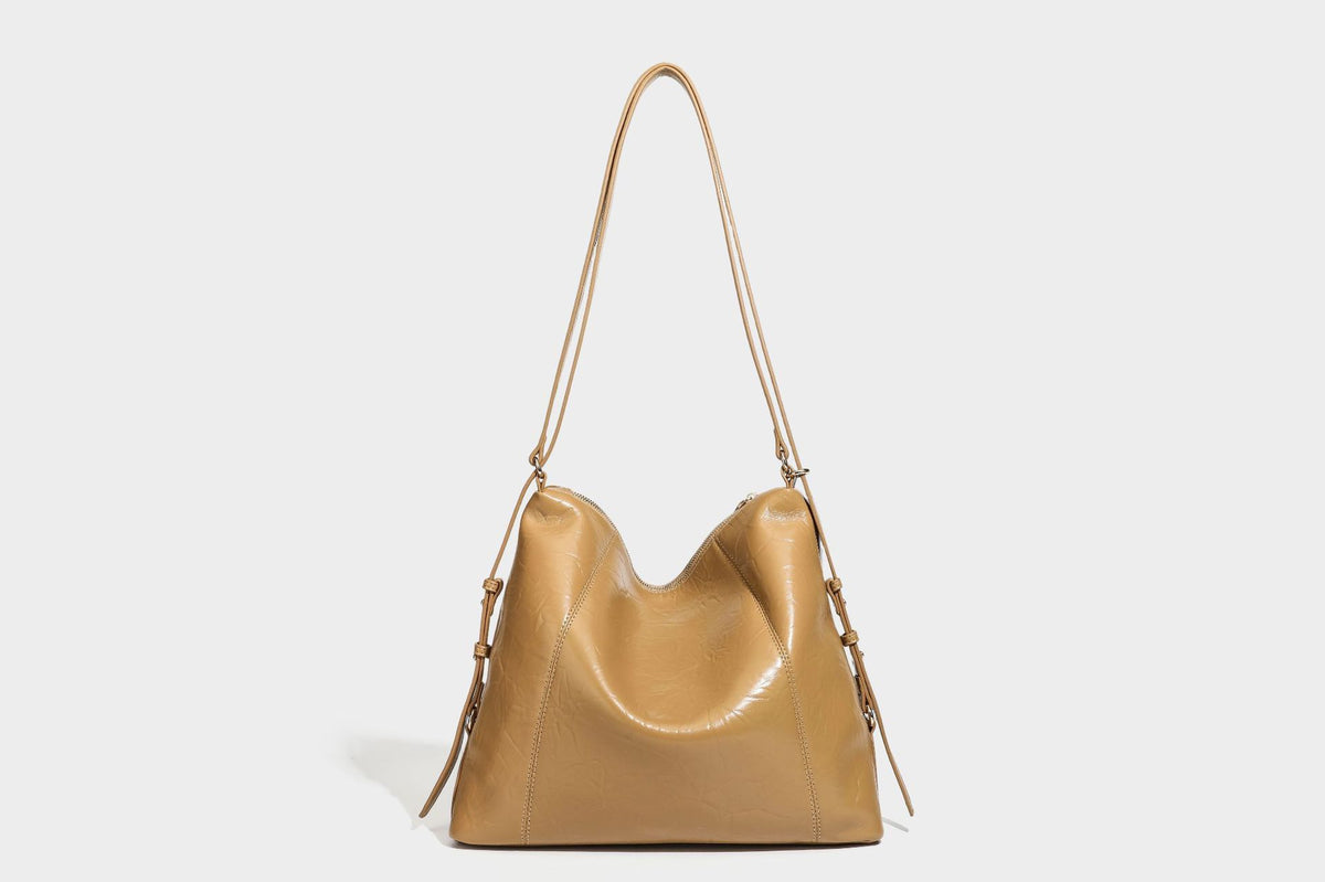 Große, lässig fallende Hobo-Schultertasche in glänzender, geknautschter Lederoptik mit goldfarbenen Beschlägen und langem, verstellbarem Riemen
