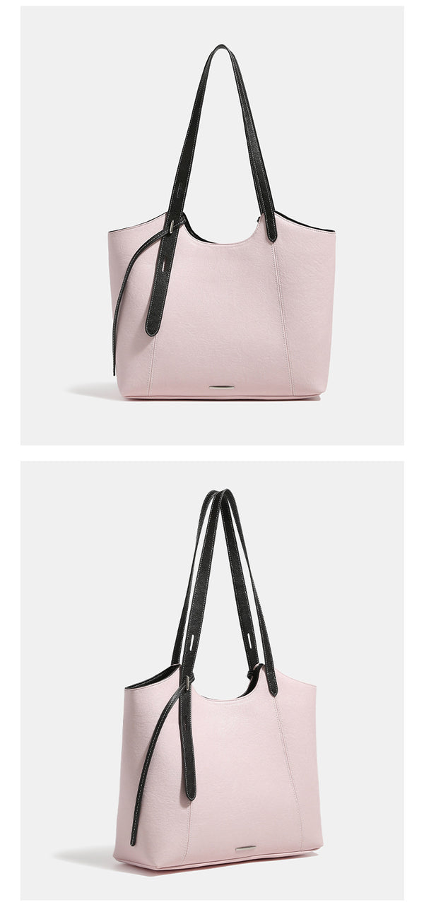 Structured trapezoidal tote bag with smooth leather-look finish, long black contrast shoulder straps, and dangling strap