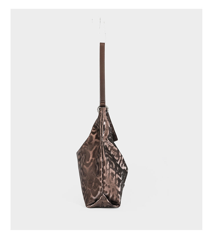 Lässige Hobo-Schultertasche mit Leopardenmuster, glänzender Satinoptik, silberfarbenen Ringbeschlägen und schmalem Schulterriemen